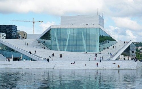 Oslo’s Opera house with people relaxing on it during the summer.